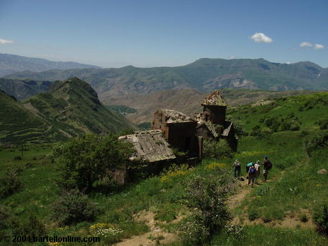 Hikers at ruins of Tsakhats Kar monastery near Artabuynk, Armenia

