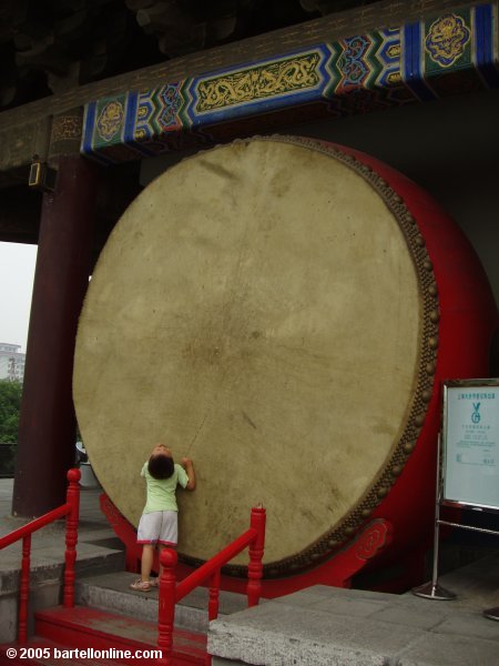 Small boy beside a big drum at the Drum Tower in Xi'an, Shaanxi, China