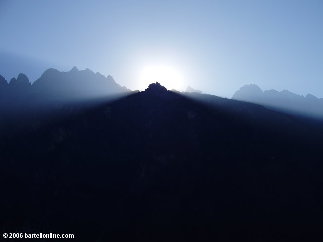 The sun peeks out from behind Jade Dragon Snow Mountain along the upper trail through Tiger Leaping Gorge in Yunnan, China