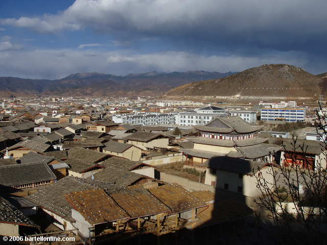 Shadow of the giant Buddhist prayer wheel in Zhongdian ("Shangri-La"), Yunnan, China falls towards a small old town monastery