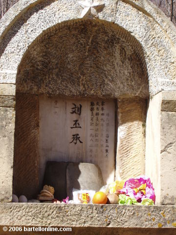 Food offerings on a grave in a cemetery in Zhongdian ("Shangri-La"), Yunnan, China