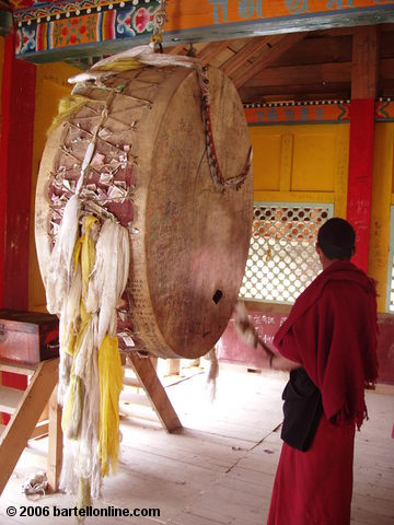 Buddhist monk beats a large drum in the Songzanlin Monastery near Zhongdian ("Shangri-La"), Yunnan, China